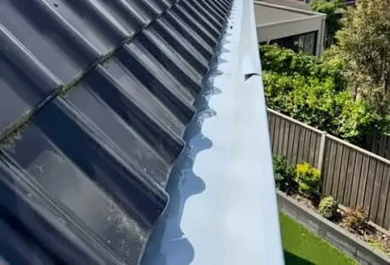 Réalisation : nouvelle gouttière le long d'un toit en tuiles après une rénovation de toiture